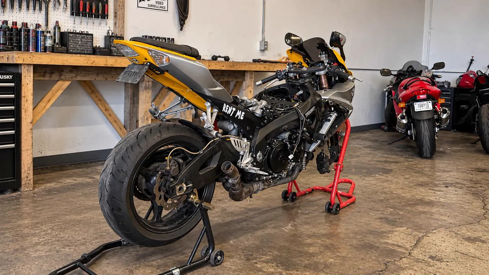 Suzuki GSX-R sportbike on paddock stands with fairings off for engine work at TT Sport Garage